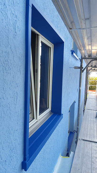 Blaue Fassade mit blauem Fensterrahmen