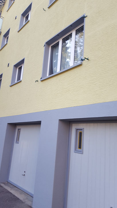 Gelbes Haus mit grauen Garagentoren